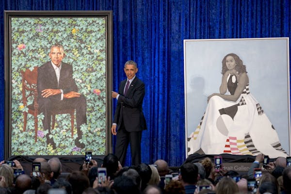 Former President Barack Obama, center, stands on stage during the unveiling of the Obama's official portraits at the Smithsonian's National Portrait G