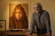 Christopher Cardozo in his Minneapolis office near a large print of the Edward S. Curtis portrait "Qahatika Girl, 1907."