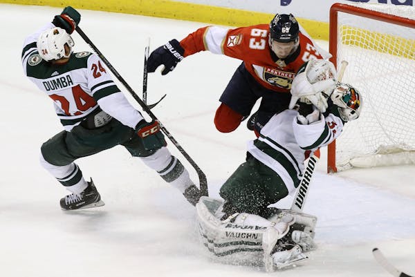 Florida Panthers' Evgenii Dadonov (63), of Russia, is called for goalie interference against Minnesota Wild goalie Alex Stalock, right, as Wild's Matt