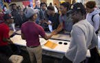 Brooklyn Center football players Junior Kai, left, Dayvia Gbor, center, and Charles Wylie, right were greeted by classmates Wednesday after they signe