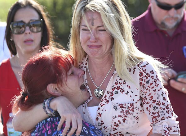 Parents wait for news after a reports of a shooting at Marjory Stoneman Douglas High School in Parkland, Fla., on Wednesday, Feb. 14, 2018. (AP Photo/