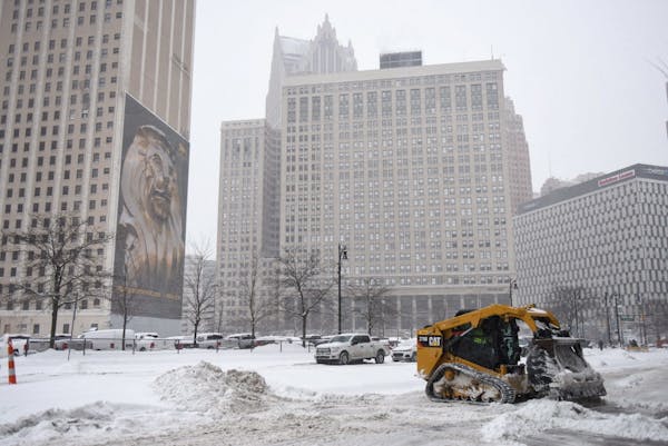 Construction equipment is used to clear snow, Friday, Feb. 9, 2018, in Detroit. (Tanya Moutzalias/The Ann Arbor News via AP)