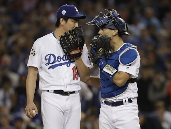 FILE - In this Oct. 31, 2017, file photo, Los Angeles Dodgers starting pitcher Kenta Maeda talks to catcher Austin Barnes during the seventh inning of