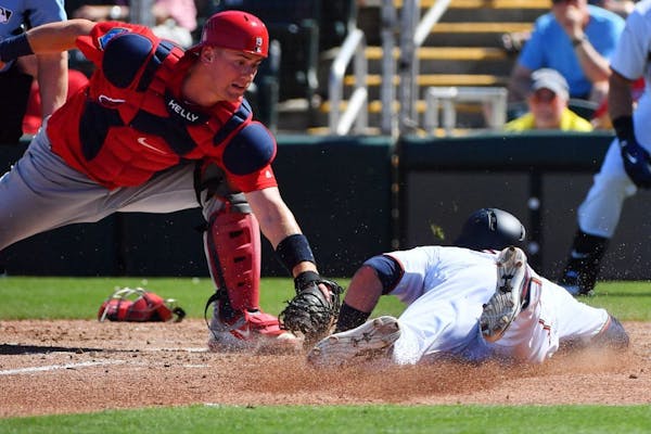 Cardinals catcher Carson Kelly tagged out Twins second baseman Brian Dozier (2) at home in the third inning.