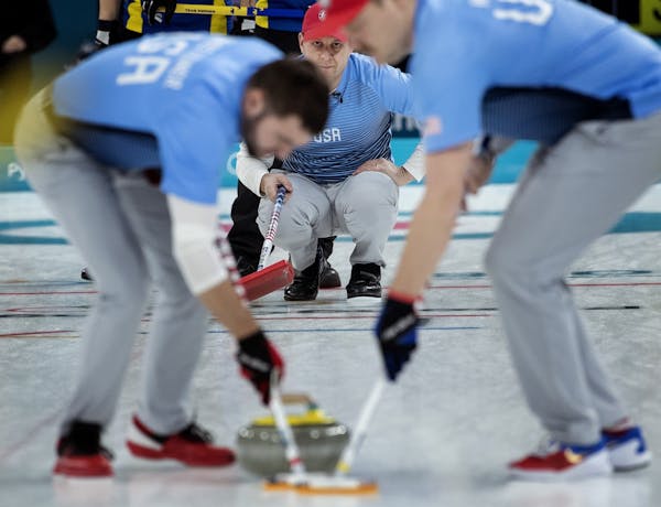 John Shuster, skip of the U.S. Olympic men's curling team, watched John Landsteiner and Matt Hamilton sweep in front of the rock at the Winter Games. 