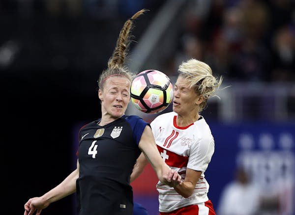 Team USA’s Becky Sauerbrunn, left, seen here heading the ball away from Switzerland’s Lara Dickenmann when they played at U.S. Bank Stadium in 201