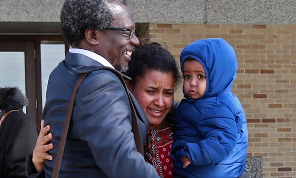 Augsburg Pro. Mzenga Aggrey Wanyama embraces his family outside the Immigration and Customs Enforcement’s headquarters after attending a meeting wit