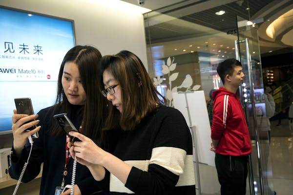 Customers try out the new Mate 10 Pro smartphone in a Huawei store in Beijing last fall. (GIULIA MARCHI/The New York Times)