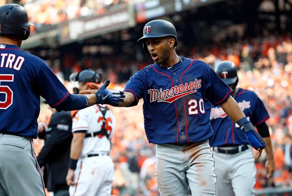 Minnesota Twins' Eddie Rosario (20) celebrates with teammate Jason Castro after scoring on a single by Robbie Grossman during the ninth inning of an o