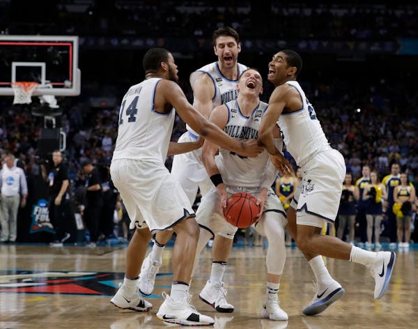 Villanova teammates surrounded championship game hero Donte DiVincenzo at the end of Monday night’s game in San Antonio.