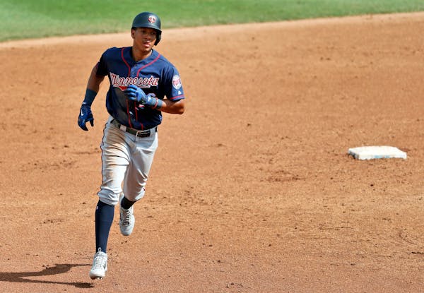 Minnesota Twins' Ehire Adrianza rounds the bases after hitting a two-run home run during the fifth inning of an exhibition spring training baseball ga