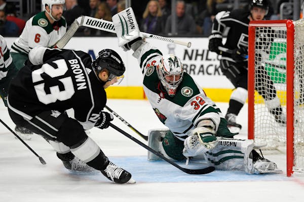 Los Angeles Kings right wing Dustin Brown, left, tries to get a shot past Wild goaltender Alex Stalock during the second period. Brown scored four goa