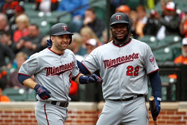 Minnesota Twins' Brian Dozier, left, celebrates his solo home run with teammate Miguel Sano in the first inning of a baseball game against the Baltimo