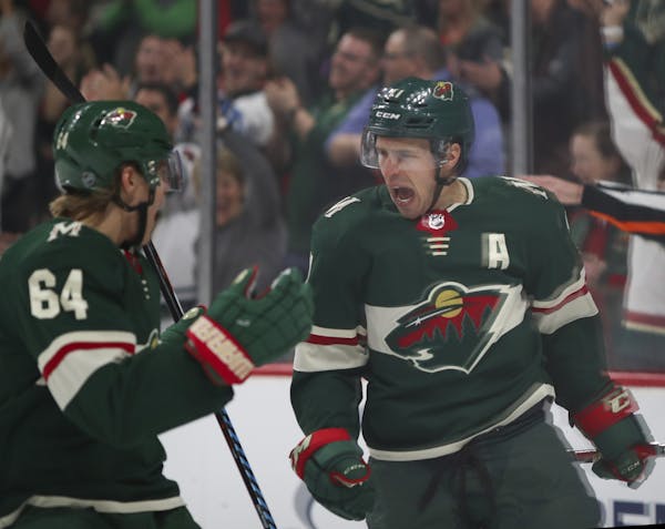 Minnesota Wild left wing Zach Parise (11) celebrated his first period goal with right wing Mikael Granlund (64).