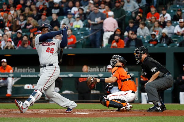 Minnesota Twins' Miguel Sano, left, watches his solo home run in front of Baltimore Orioles catcher Caleb Joseph and home plate umpire Doug Eddings in