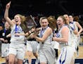 Eastview guard Emma Carpenter (4) held the team's championship trophy as she rushed toward the student section with teammates following their 68-63 4A