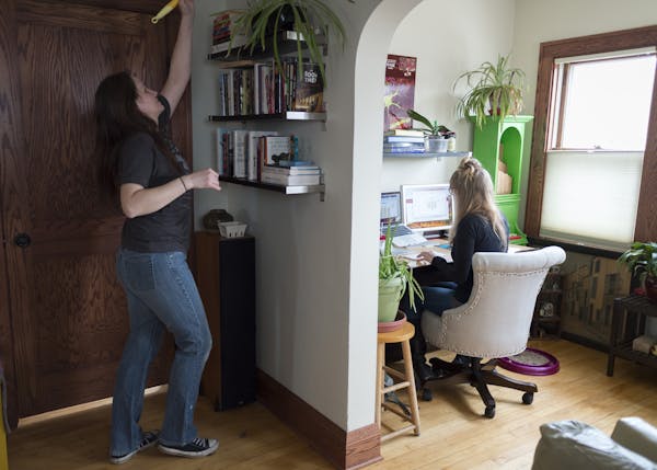 Housekeeper Jennifer Kraskey dusted at the Minneapolis home of U cancer researcher and Ph.D. student Emily Pomeroy, who used the time to catch up on e