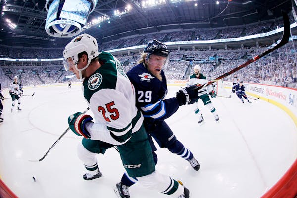 Winnipeg Jets' Patrik Laine (29) checks Minnesota Wild's Jonas Brodin (25) during the second period of Game 1 in an NHL hockey first-round playoff ser