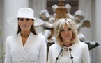 First lady Melania Trump, left, and Brigitte Macron, wife of French President Emmanuel Macron, pause for a photograph together as they tour the Nation