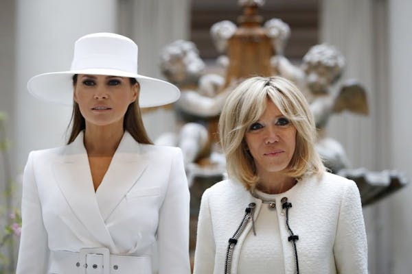 First lady Melania Trump, left, and Brigitte Macron, wife of French President Emmanuel Macron, pause for a photograph together as they tour the Nation