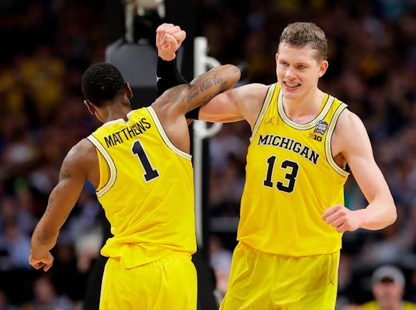 Michigan's Moritz Wagner (13) celebrates with Charles Matthews (1) during the second half in the semifinals of the Final Four NCAA college basketball 
