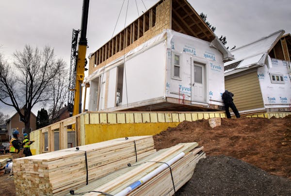 Crews working with Sm+RT Homes moved two modular houses from tractor trailer trucks and set them on foundations with a huge crane in East St. Paul. ] 