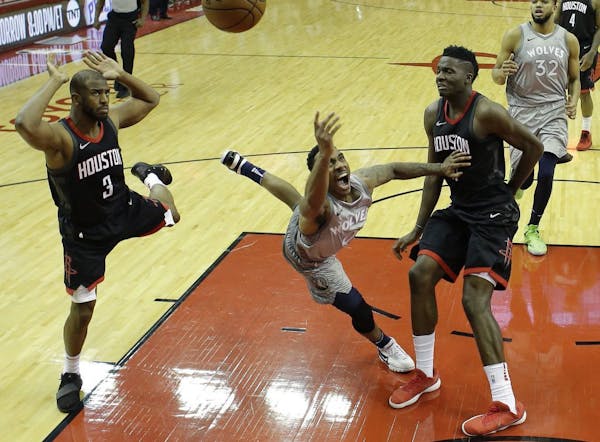 Minnesota Timberwolves' Jeff Teague, center, shoots between Houston Rockets' Chris Paul, left, and Clint Capela during the second half in Game 1 of a 
