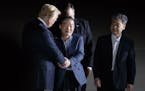 President Donald Trump shakes hands with Kim Dong-chul, as Kim Hak-song, right, looks on, as they arrive to Joint Base Andrews, Md., early Thursday mo