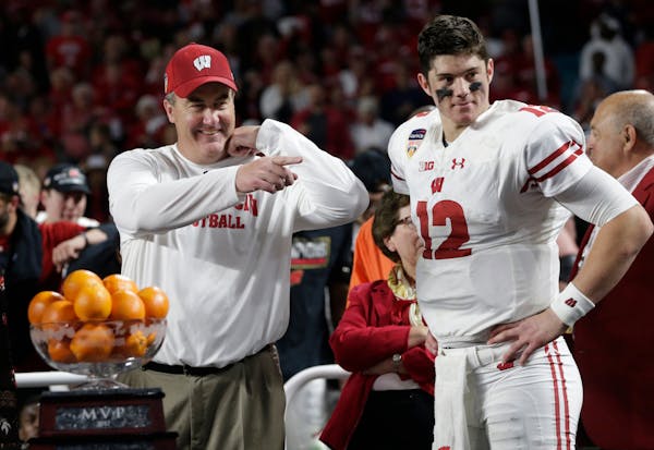 Wisconsin coach Paul Chryst and quarterback Alex Hornibrook stood next to the MVP trophy at the end of the Orange Bowl in Miami.