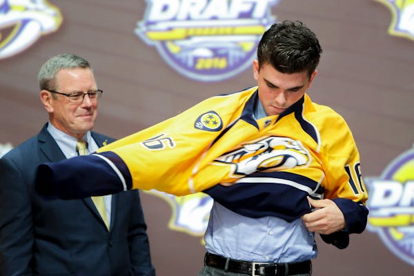 Dante Fabbro put on a Predators jersey after being selected 17th overall in the 2016 NHL draft as Predators assistant GM Paul Fenton looked on. Fenton