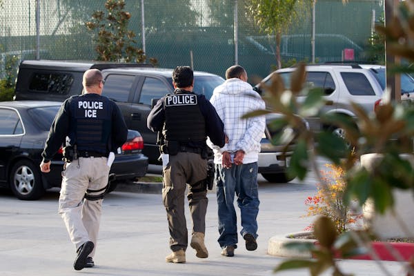 Immigration and Customs Enforcement agents take a suspect into custody,
