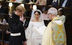 Britain's Prince Harry and Meghan Markle hold hands in St George's Chapel at Windsor Castle during their wedding service, conducted by the Archbishop 