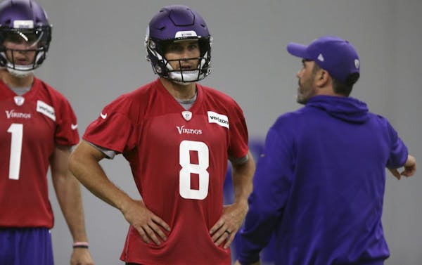 Minnesota Vikings quarterback Kirk Cousins (8) listens to instructions from quarterback coach Kevin Stefanski during practice at the NFL football team