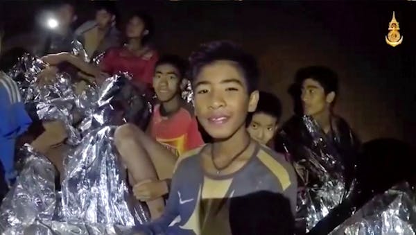 FILE - In this July 3, 2018, file image taken from video provided by the Royal Thai Navy Facebook Page, the boys smile as Thai Navy SEAL medic help in