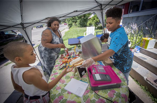 Thirteen-year-old hot dog entrepreneur Jaequan Faulkner served up a hot dog meals to Yvonne Ross and her son Drameris Ross, 7, at his hot dog stand, M