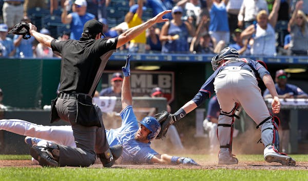 The Royals' Drew Butera slid into home ahead of the tag of Twins catcher Mitch Garver after hitting a three-run, inside-the-park home run during the s