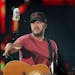 After taking a sip, headliner Luke Bryan tossed a cold one into the crowd while performing Saturday, July 21, 2018, at Target Field in Minneapolis, MN