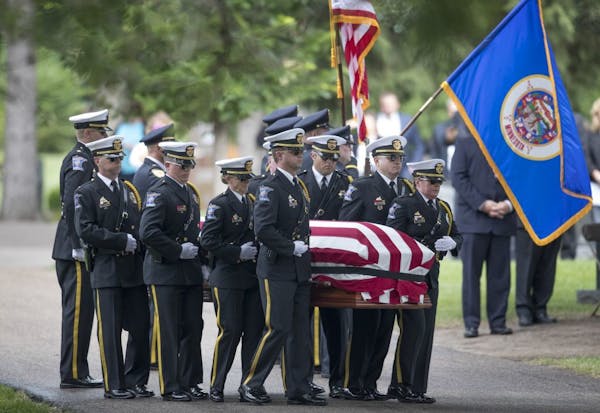 Pallbearers carried the body of correction officer Joseph Gomm to his gravesite at Roselawn Cemetery in Roseville on Thursday.
