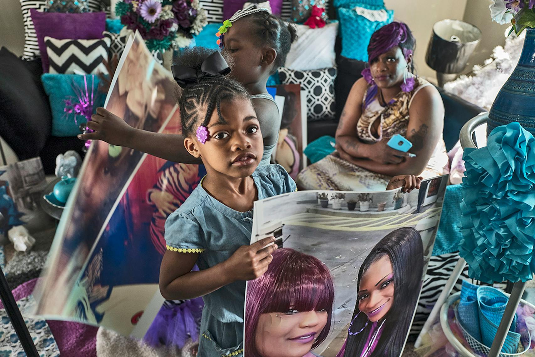 Tyna'ja Hornsby 6, held a photo of her sister Tyneshia Pate with her mother, Michelle, at the family home in Brooklyn Park.