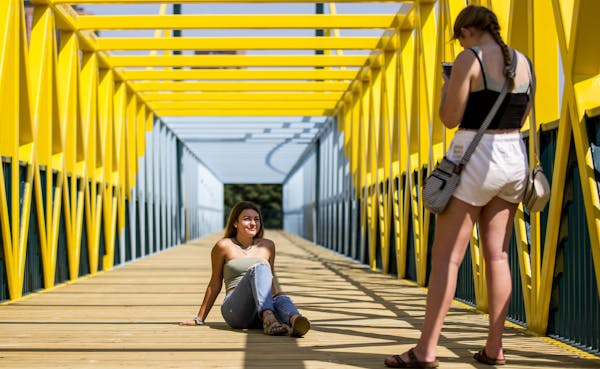 (Left) Marie Pfeilsticker and Kayla Lysne from Delano, MN spent part of their Friday afternoon takin pictures of each other on the bridge. ] ALEX KORM