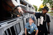 Damion Reid, of the Lind-Bohanon neighborhood of Minneapolis, reached over officer Erin Grabosky, with a Minneapolis police mounted unit, during a Nat
