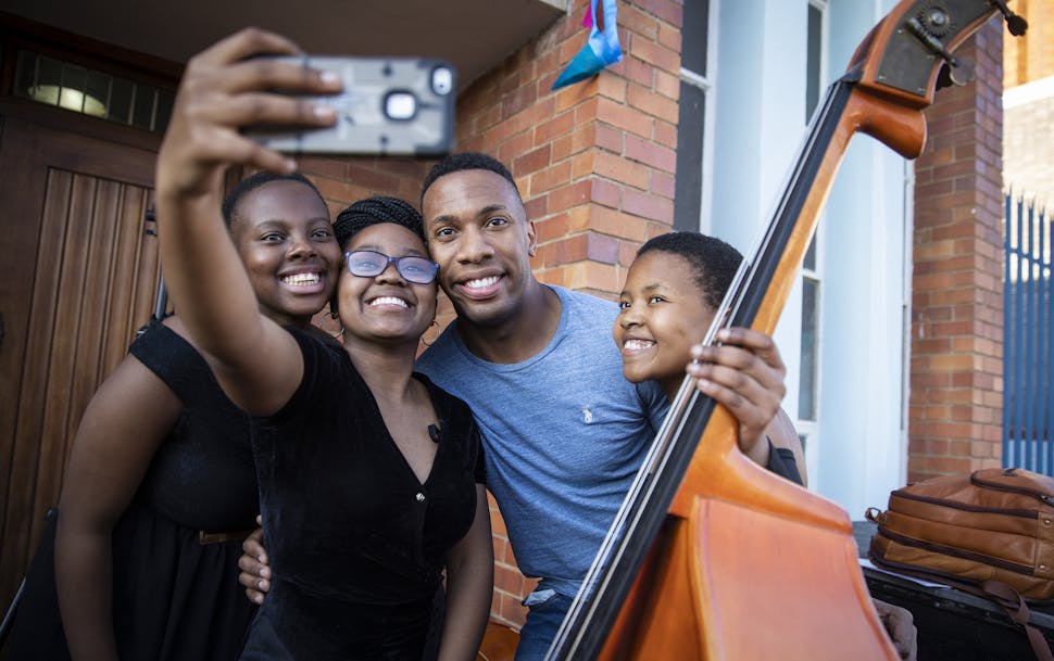 Minnesota Orchestra associate conductor Roderick Cox posed with South African National Youth Orchestra members Boitumelo Mtsatse, Refilwe Moeketsane a