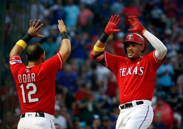 The Rangers' Rougned Odor (12) congratulated Ronald Guzman (67) after Guzman's three-run home run against the Twins during the second inning.