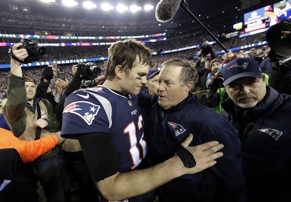 New England Patriots quarterback Tom Brady, left, hugs coach Bill Belichick after the AFC championship NFL football game against the Jacksonville Jagu