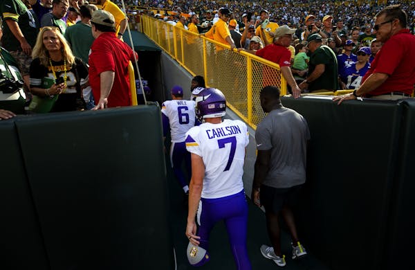 Vikings kicker Daniel Carlson (7) walked off the field after missing a field goal at the end of overtime.