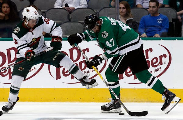 Wild center Justin Kloos, left, and Stars winger Alexander Radulov battled for the puck during the second period of a preseason NHL game Monday.