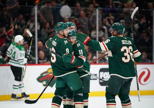 Wild left wing Zach Parise (11) was congratulated by teammates, including center Mikko Koivu (9) and defenseman Nick Seeler (36) after he scored in th