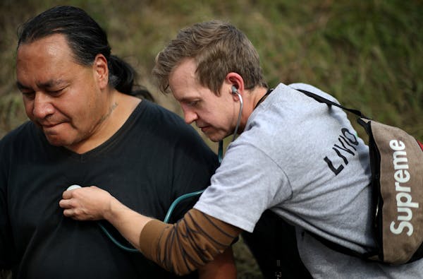 Lewis Simpler a member of a team of nurses with Livio Health Group took the vital signs of Anthony Nichols 52, at the large homeless camp on Monday in
