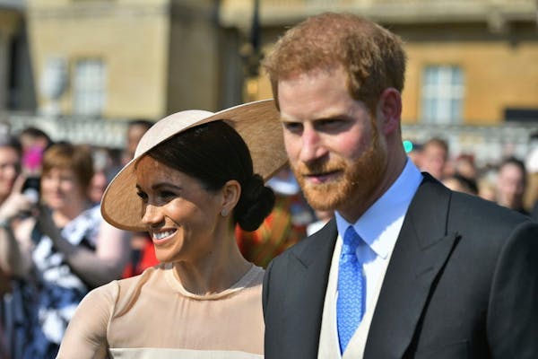 Meghan, the Duchess of Sussex walks with her husband, Prince Harry as they attend a garden party at Buckingham Palace in London, Tuesday May 22, 2018.