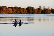 A rowing crew skimmed across a placid Lake Nokomis with fall colors and the Minneapolis skyline Thursday, Oct. 18, 2018, in Minneapolis.